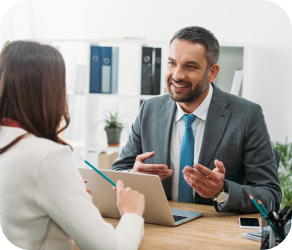 A man in a suit and tie discussing insurance with a woman at a desk